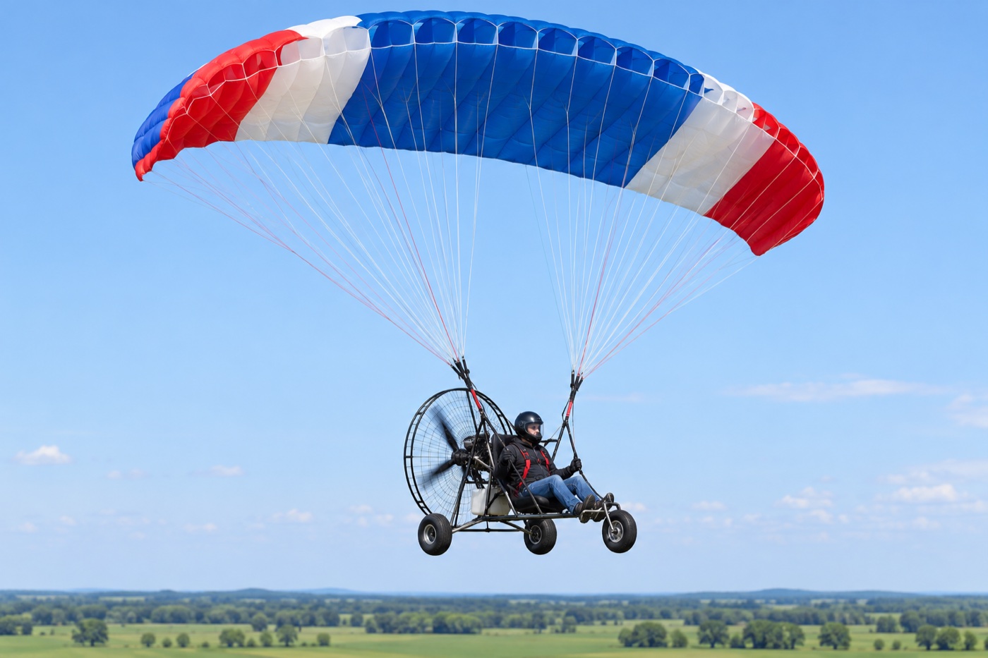 Single-seat powered parachute with a ram-air wing and wheeled cart.
